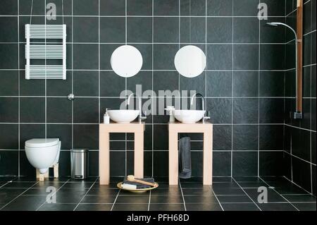 Badezimmer mit zwei Waschbecken, Wc und Dusche, Wand und Boden Fliesen- in Schwarz Stockfoto