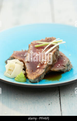 Grill - gebratene doppelt dick Thunfischsteaks mit eingelegten Ingwer, Wasabi und Sojasauce, auf blauem Teller serviert Stockfoto