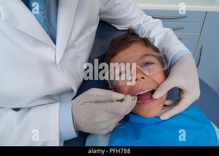 Zahnarzt Holding parodontalen Sonde in Boy's Mund Stockfoto