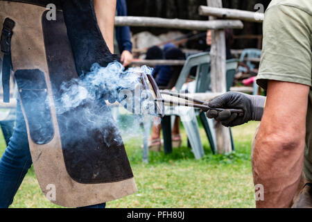 Nahaufnahme der menschlichen Hände Hot Shoe auf Pferd Paw Stockfoto