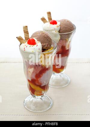 Knickerbocker Glory, Eis, Pfirsiche und Sahne, garniert mit Kirschen und Wafer Kekse, in zwei Gläsern serviert, close-up Stockfoto