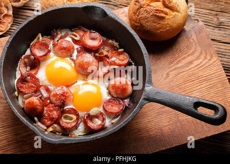Gekochte Eier und Würstchen auf Pfanne Stockfoto