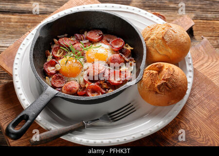 Gekochte Eier und Würstchen auf Pfanne Stockfoto