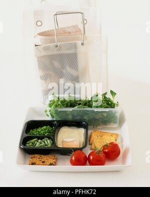 Salatblätter in Feld, Gemüse, Lachs, Tomaten und Cracker auf Fach, neben Shopping Bag, der ein Zeitung Stockfoto