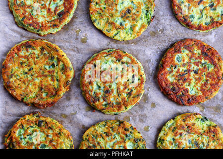 Lecker gebacken in Backofen lecker Zucchini Krapfen auf Backpapier, gesund und einfach vegetarisch Rezept, Ansicht von oben Stockfoto