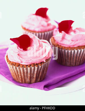 Drei schoko Cupcakes mit Rosa buttercream frosting eingerichtet, aus der Nähe. Stockfoto