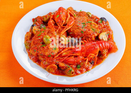 Huhn Marengo - Huhn Fleisch Eintopf mit crawfishies, gehackt Tomatensauce, Zwiebeln, Pilze, Oliven, auf weißer Teller am Tisch Matte, Ansicht von oben, Cl Stockfoto