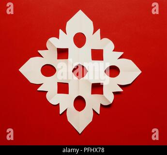 Weißbuch Schneeflocke auf rotem Hintergrund Stockfoto