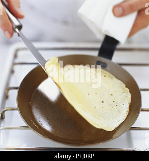 Pfannkuchen gewendet mit einem Spachtel in der Pfanne, von oben betrachten Stockfoto