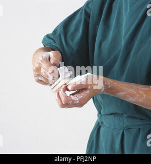 Chirurg Reinigung der Hände mit einem Pinsel und Seife Stockfoto