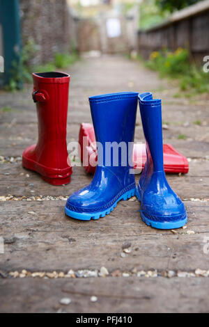 Zwei Paare von Rot und Blau für Kinder Gummistiefel in der Gasse Stockfoto