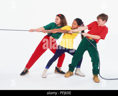 Zwei Mädchen und ein Junge spielt "Tauziehen" Stockfoto
