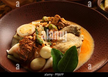 Ketupat Lebaran, die traditionelle feierliche Reisgericht mit Kuchen mit mehreren Beilagen; beliebt während Eid feiern. Stockfoto