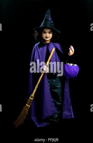 Mädchen verkleidet als eine Hexe, Besen und Tasche Stockfoto