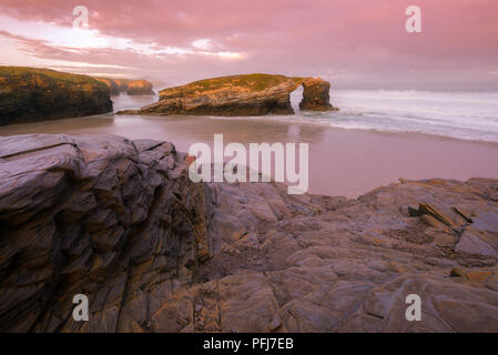 Amanecer con Tintes violetaen La famosa Playa de als Catedrais Ribadeo Galicien, en Stockfoto