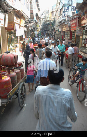 Südasien, Indien, Delhi, Menschen zu Fuß nach oben und unten einen langen schmalen Straße, Benzinkanister, Radfahrer Stockfoto