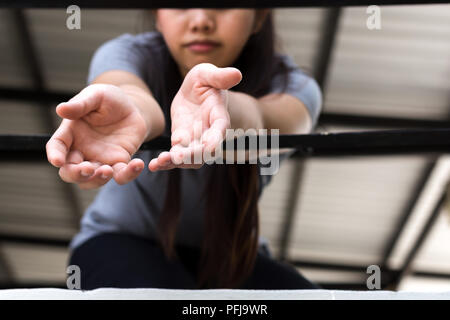 Junge Frau Opfer Hand erreichen, um Hilfe von einem Metal bars Stockfoto