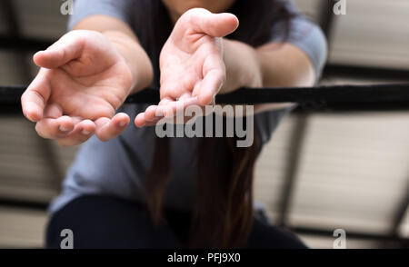 Junge Frau Opfer Hand erreichen, um Hilfe von einem Metal bars Stockfoto