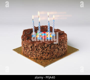 Geburtstag Schokolade Kuchen, mit Schokolade Spänen eingerichtet, bunte Bonbons und sechs Kerzen Stockfoto