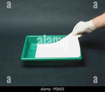 Behandschuhte hand Einlegen von Papier in ein Fach zu entwickeln Stockfoto