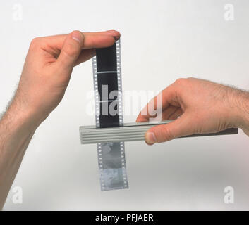 Mit einer Länge von 35-mm-Film mit der Zange Stockfoto