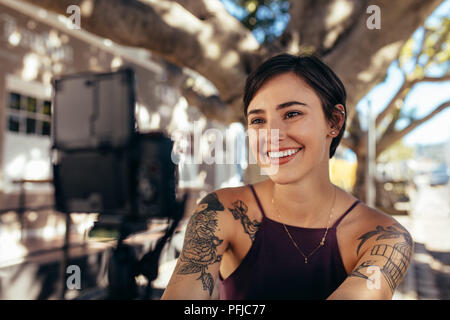 Glückliche Frau vlogger Dreharbeiten Video Blog im Freien. Lächelnd weibliche, vlog mit Digitalkamera in der Stadt. Stockfoto