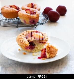 Pflaume friands auf einem Teller und auf die Kühlung Rack im Hintergrund, mit frischen Pflaumen in der Nähe Stockfoto