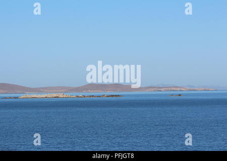 Felsigen Küsten und Klippen der Insel Mykonos im Abstand über die Ägäis Stockfoto