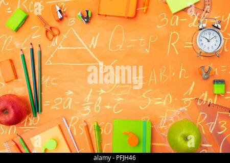 Zurück zu gestalteten Schule flach Rahmen mit bunten Schulmaterial auf orange Hintergrund mit mathematischen Formeln Stockfoto