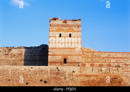 Asien, Türkei, Istanbul, Frontansicht Teil der Wände von Theodosius II., aus rotem Backstein Muster, quadratischen Turm mit zwei kleinen Fenstern in der Nähe der Oberseite, tief blauen Himmel hinter sich. Stockfoto