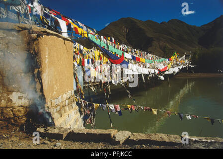 Tibet, Lhasa, Linien von Gebetsfahnen auf dem Fluss Stockfoto