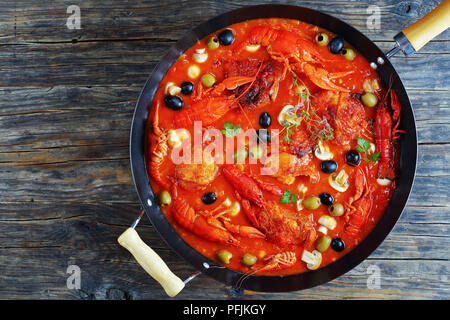 Huhn Marengo - lecker Hühnerfleisch Eintopf mit crawfishies, gehackt Tomatensauce, Zwiebeln, Champignons, Oliven, Thymian in Pfanne, Ansicht von oben, bla Stockfoto