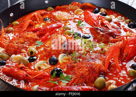 In der Nähe von Huhn Marengo - Huhn Fleisch Eintopf mit crawfishies, gehackt Tomatensauce, Zwiebeln, Champignons, Oliven, Thymian in Skillet auf Holz Küche w Stockfoto