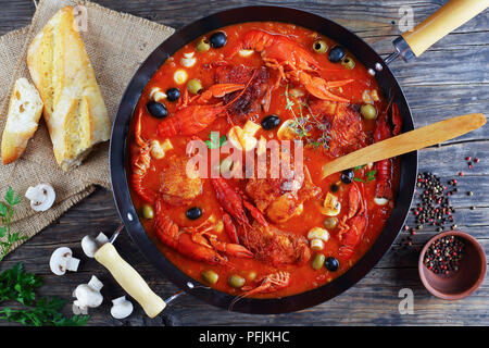 Huhn Marengo - Huhn Fleisch Eintopf mit crawfishies, gehackt Tomatensauce, Zwiebeln, Pilze, Oliven, Thymian in Skillet auf Küche aus Holz Bretter mit f Stockfoto