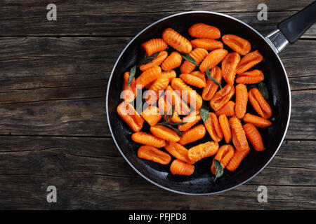 Lecker heißer Kürbis Gnocchi in Butter gebraten mit frischen Salbeiblättern in Pfanne, horizontale Ansicht von oben Stockfoto