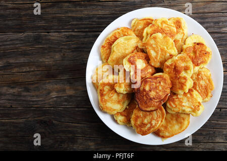 Apfel griechischer Joghurt Pfannkuchen - dicke, flauschige und geladen mit saftigen Stücke Obst, auf weißem Schild auf alten, dunklen Holz- Tabelle, Ansicht von oben Stockfoto