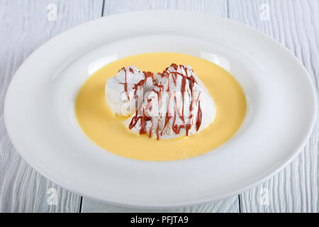 Elegante französische Dessert - eine schwimmende Insel ist ein Dessert französischer Herkunft, bestehend aus Baiser schwimmend auf Creme Anglaise oder Vanillepudding servieren Stockfoto