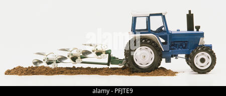 Spielzeug Traktor mit Pflug, Seitenansicht Stockfoto