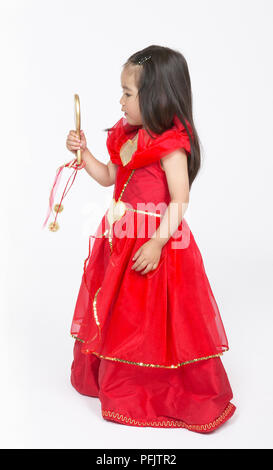 Mädchen in Rot prinzessin kleid Suchen in Gold in der Hand gehaltenen Spiegel, Seitenansicht Stockfoto