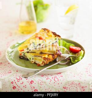 Gemüse frittata und Salat auf einen Teller geben, mit einer Gabel Stockfoto