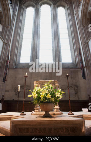 Grossbritannien, England, Hampshire, Romsey, Romsey Abbey, Blick auf die Urne von Blumen vor dem Taufbecken, unterhalb der West Fenster Stockfoto