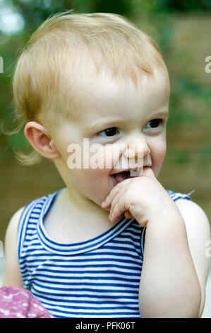 Baby Boy mit dem Finger in den Mund und weg schauen, close-up Stockfoto