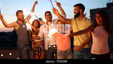 Freunde Party mit Wunderkerzen auf der Dachterrasse genießen. Stockfoto