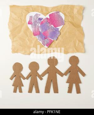 Herz aus Papier mit bemalten Folie auf braunem Papier eingerichtet und Papierkette Männer aus Karton Stockfoto