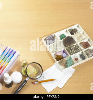 Verschiedene Gesteine, Edelsteine und Kristalle in Kunststoff Fach, Karteikarten, Bleistift, Korrekturflüssigkeit, Watte, Vergrößerungsglas Stockfoto