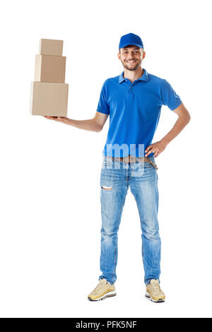 Volle Länge Portrait von lächelnden Delivery Man holding Stapel von Kartons in einer Hand auf weißem Hintergrund Stockfoto