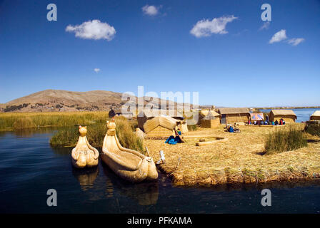 Peru, Titicacasee, Uros schwimmende Inseln, Insel mit Reed Hütten auf ihm und Reed Boote in der Nähe Stockfoto