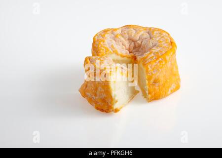 Runde und Scheibe des französischen Langres AOC Käse aus Kuhmilch, versunkene Orangenschale Stockfoto