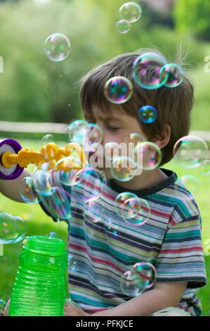 Junge im gestreiften T-Shirt blasen blasen, close-up Stockfoto