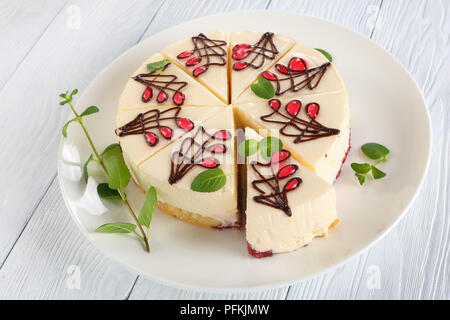 Köstliche reich verzierten Käsekuchen mit frischen grünen Minze auf weißen platter auf Holztisch, horizontale Ansicht von oben, close-up Stockfoto